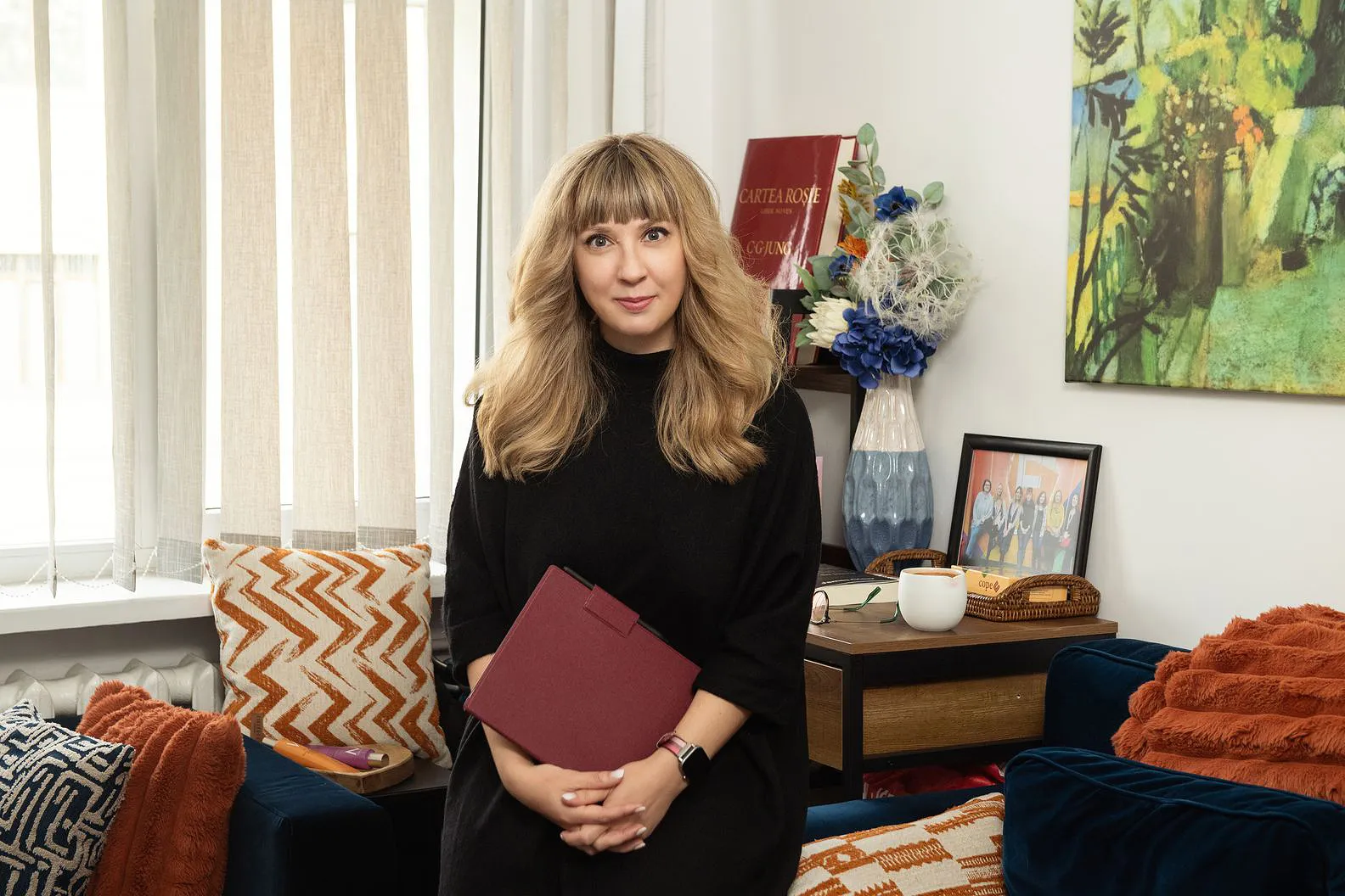 Portret Andreea Negruti, așezată pe canapea în cabinet